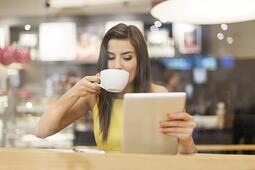 woman_in_coffee_shop_with_guy_in_background Learning in a coffee shop