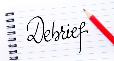 debrief activities for adults, debrief is written on a piece of paper